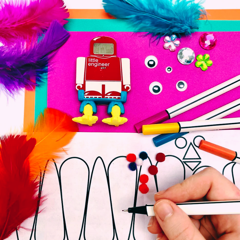 Craft materials and a robot toy with colorful feathers, representing Engineering Arts and Math creativity.