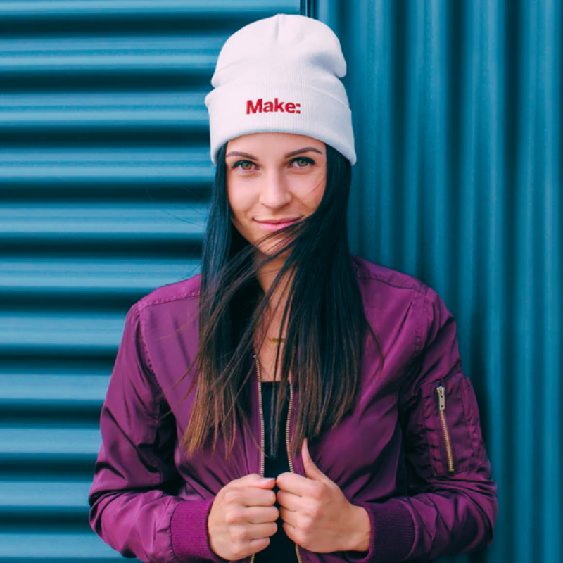 Model wearing a white beanie and purple jacket from Gifts and New Merch collection.