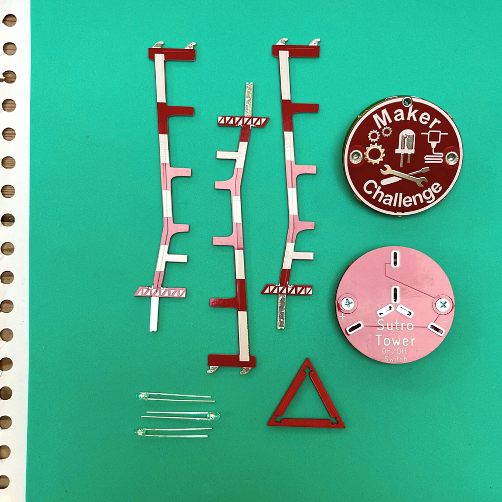 Soldering Kit: Sutro Tower components including circuit pieces, LED lights, and challenge badge on green background.