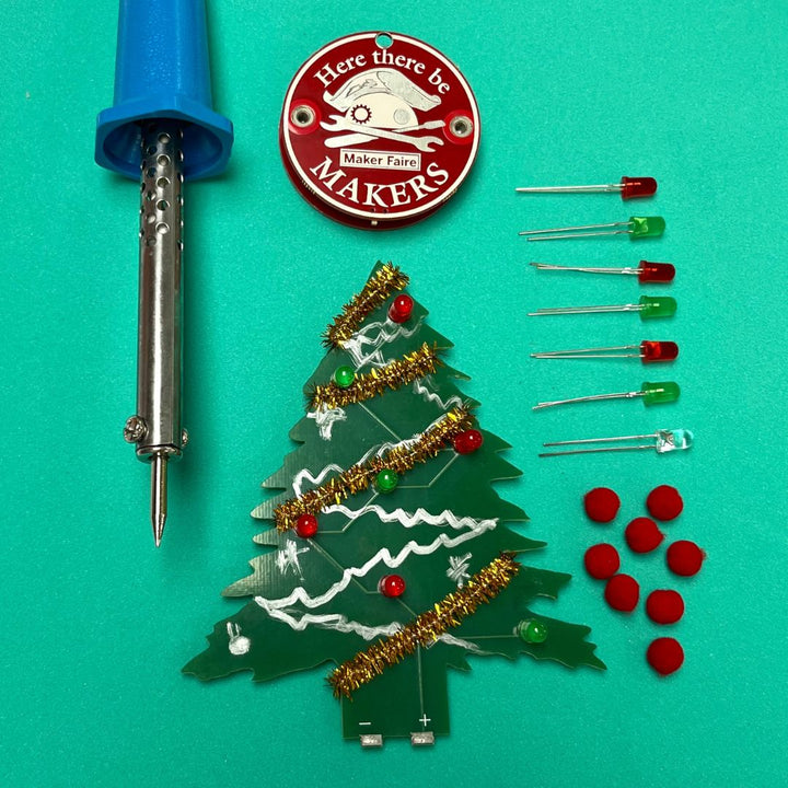 Learn To Solder - Holiday Tree kit with PCB, LEDs, and soldering iron for creative projects.