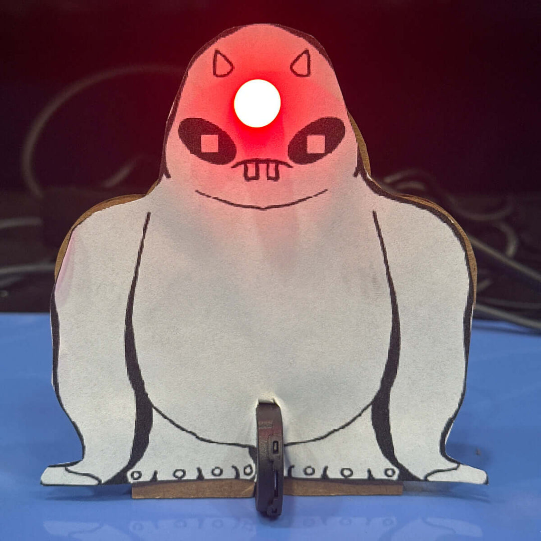 Make A Monster Craft Kit featuring a monster with a red light on its head, standing on a blue surface.
