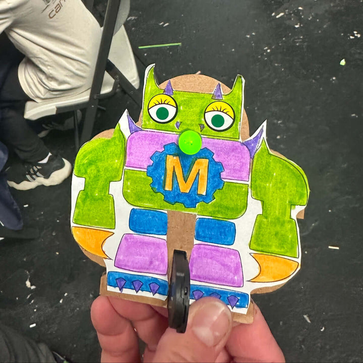 Colorful papercraft cutout of a monster character with a &