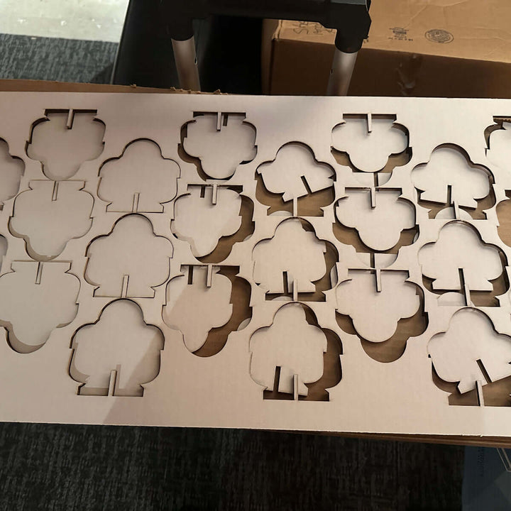 Makey robot-shaped cutouts popping out of a cardboard backing