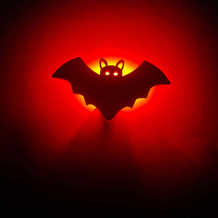 Bat-shaped LED wooden project with a glowing red background