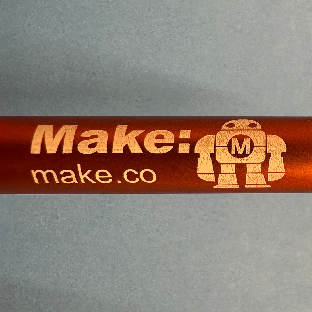 Orange pen with Makey the robot and &