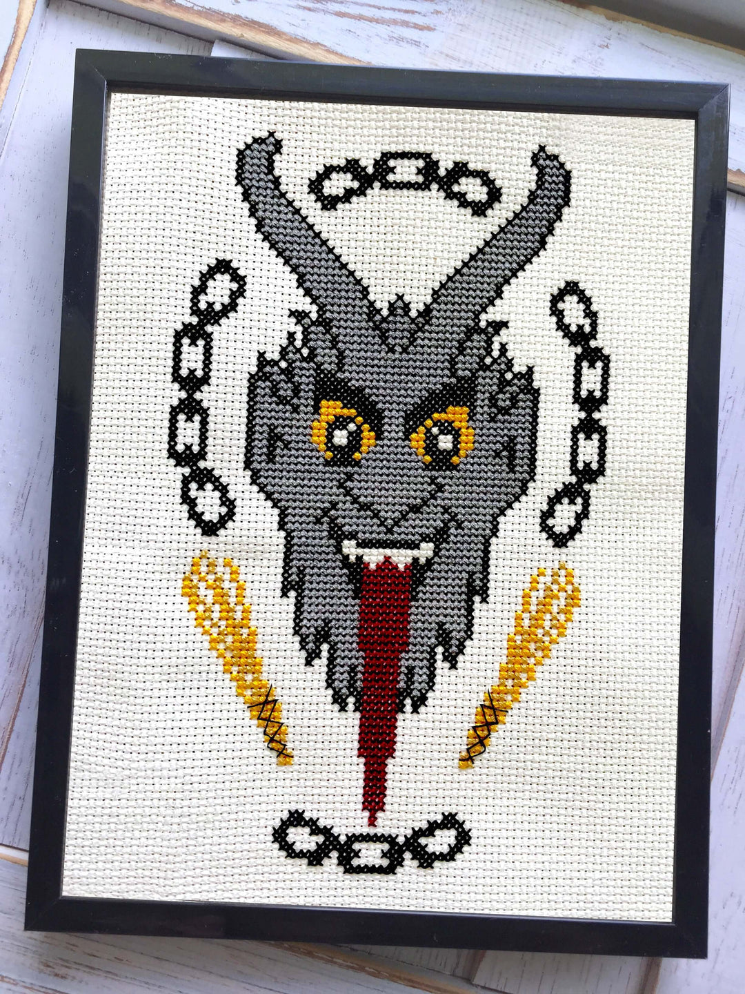 The Krampus Counted Cross Stitch DIY Kit finished design featuring a menacing Krampus portrait in a frame.