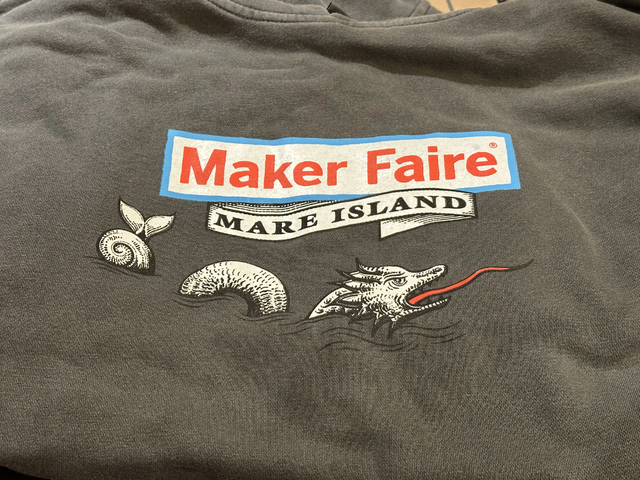 Grey Maker Faire Mare Island hoodie with up close shot of logo.